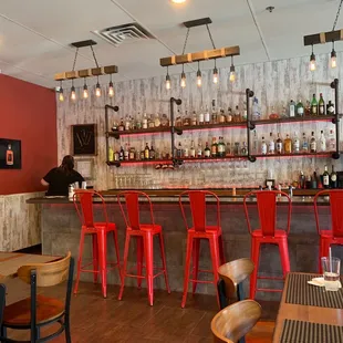 a bar with red chairs