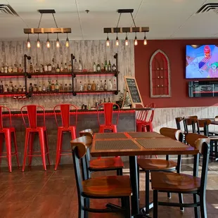 a bar with red chairs
