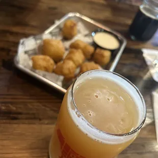 a pint of beer and fried chicken nuggies
