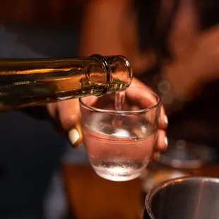 a person pouring wine into a glass