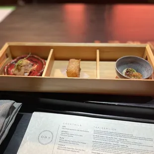a wooden tray with a variety of food items