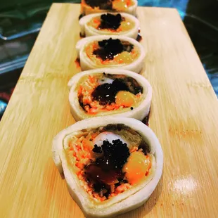Village Roll , ( cucumber wrap with backed eel , shrimp tempura, spicy crab meat, top with black tobiko and eel sauce.