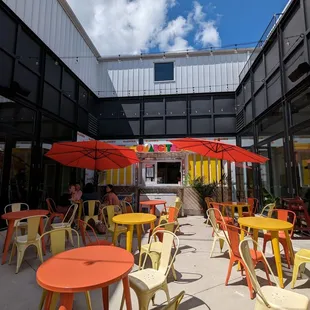 a courtyard with tables and umbrellas