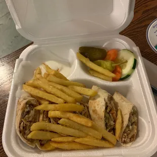 a sandwich and fries in a styrofoam container