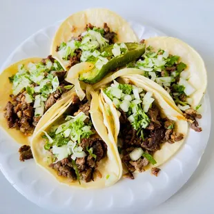 three tacos on a paper plate