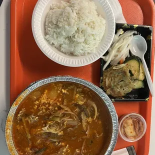 a bowl of soup, rice, and vegetables