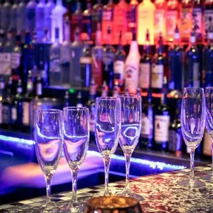 wine glasses lined up on a bar