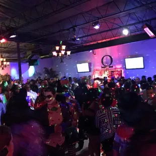 a large group of people dancing at a party