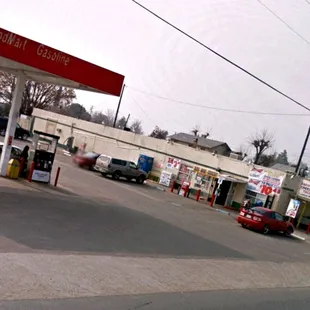 a gas station with cars parked in the lot