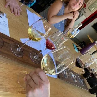a woman sitting at a table with several glasses of wine