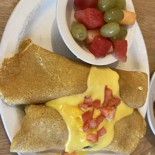 Spinach crêpes with a bowl of fruit instead of hashbrowns