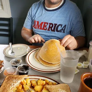 a man sitting at a table with a plate of food