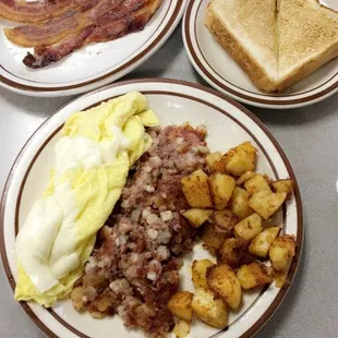 Crispy bacon, cheese omelette, amazing corned beef hash with home fries and toast! Breakfast of champions!