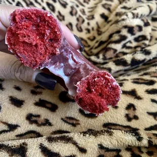 a hand holding a half eaten donut