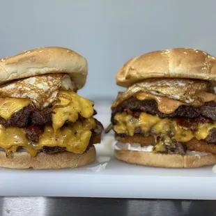 two cheeseburgers on a cutting board