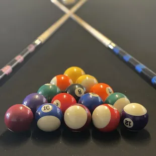 a pool table with billiards and cues
