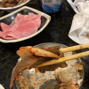 a bowl of food with chopsticks