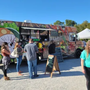 a group of people standing in front of a food truck