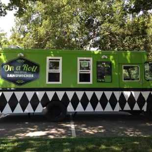 a green food truck parked in a parking lot