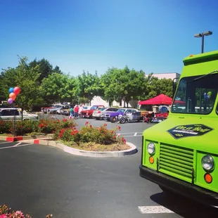 a green food truck parked in a parking lot
