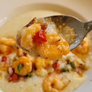 a spoon full of shrimp and grits