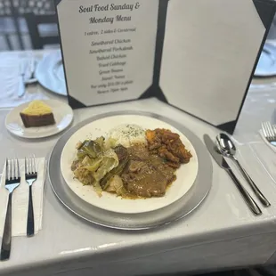 Smothered pork steak with rice, fried cabbage, sweet potatoes