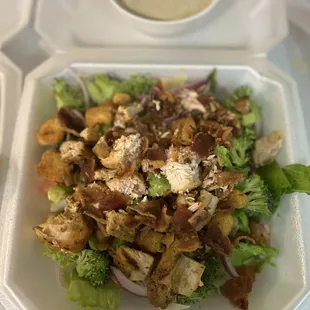 a salad in a styrofoam container