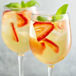 two glasses of champagne with strawberries and mint