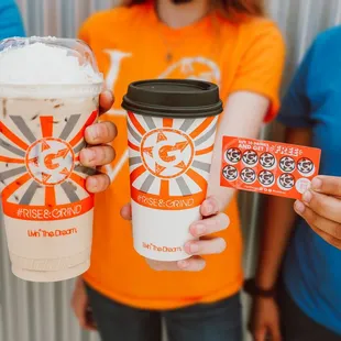 a person holding a starbucks cup and a starbucks card