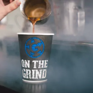 a person pouring coffee into a cup