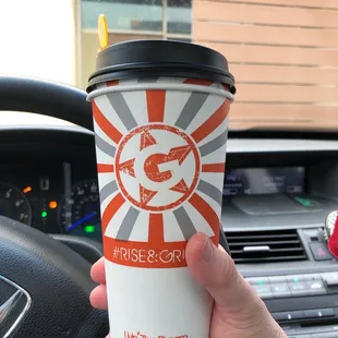 a hand holding a coffee cup