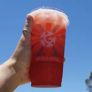 a hand holding a cup of juice