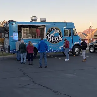 a group of people standing in front of a food truck