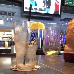 a glass of water with a straw and a lemon slice