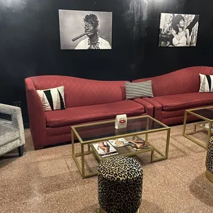 a living room with a red couch and a leopard print ottoman
