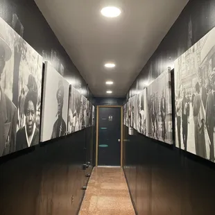 a long hallway with black and white photos