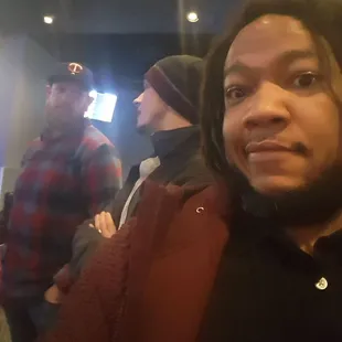 a man with dreadlocks standing in front of a group of people