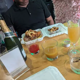 Bottle of champagne with OJ and strawbeery flavors for mimosas