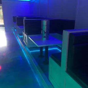a row of booths with blue lights