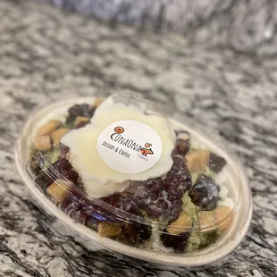 a plastic container filled with nuts and raisins