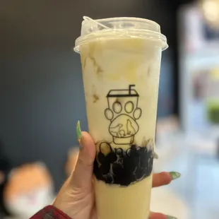 a hand holding a cup of iced tea