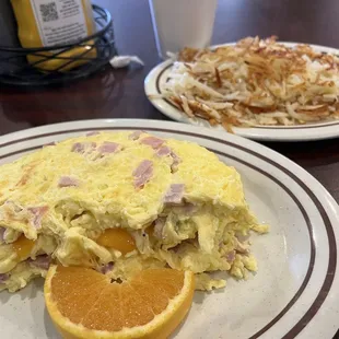 Ham and cheese omelette with hash browns on the side.