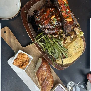 Bone in rib eye and bread loaf with homemade butter and picked mustard seeds