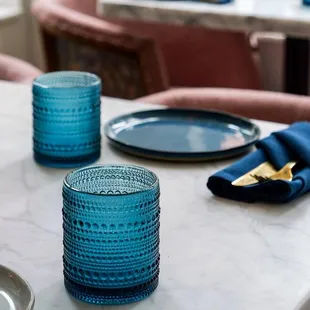 a table setting with blue glassware