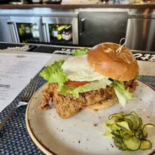 a plate with a sandwich and pickles