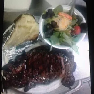 a plate of steak and a salad