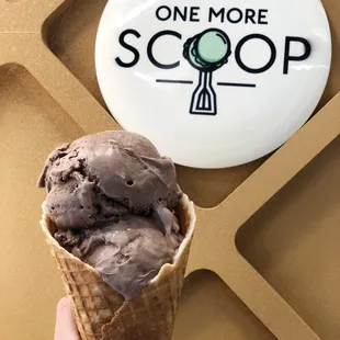 a hand holding a cone of ice cream