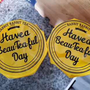 a pair of yellow plastic cupcakes with the words have a beautiful day written on them