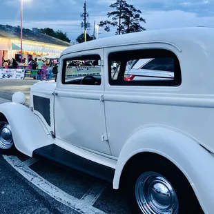 a classic car parked in a parking lot