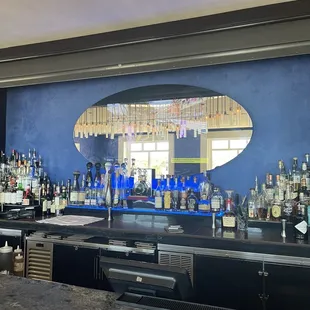 a bar with a large mirror on the wall